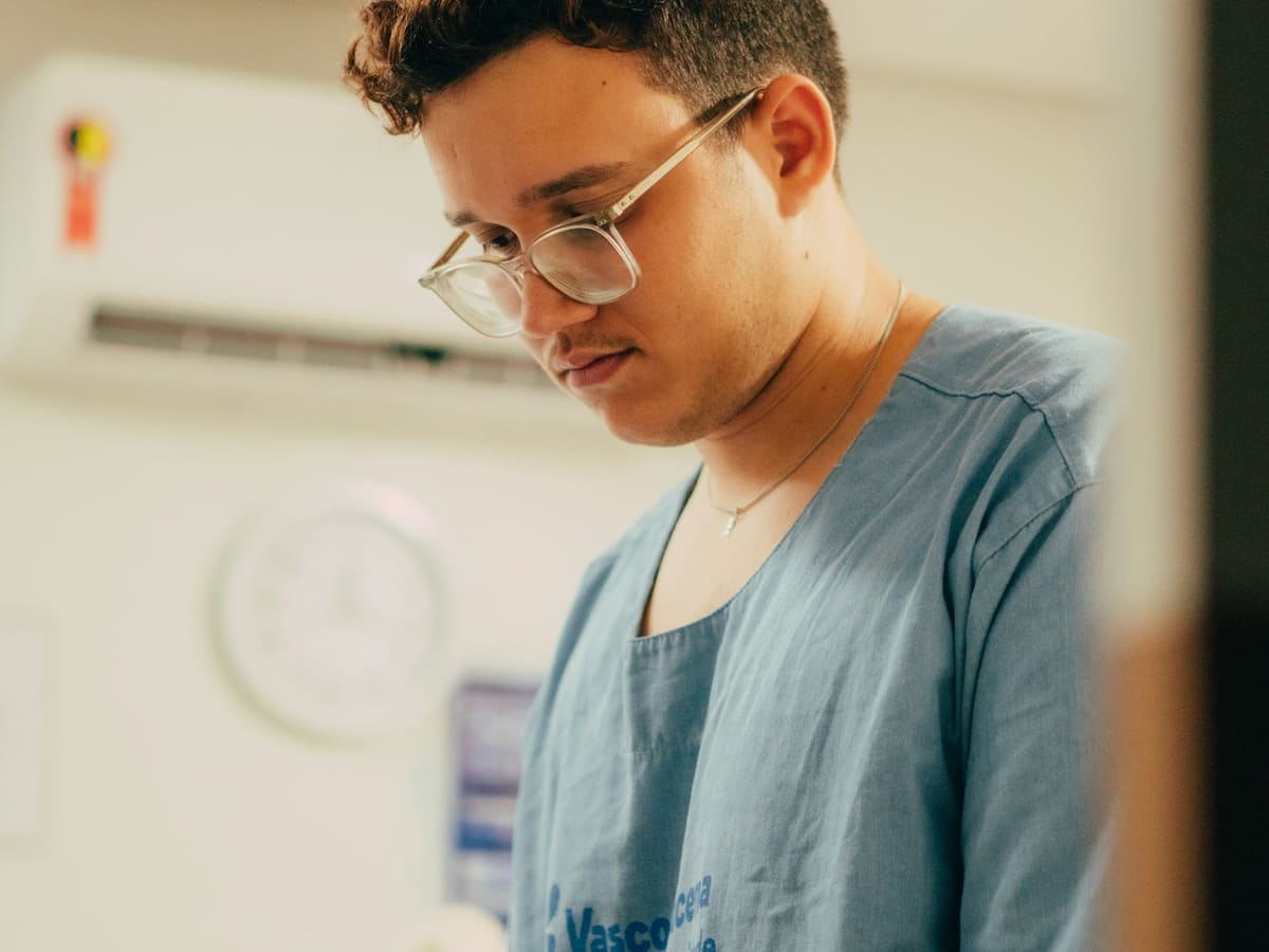 A young man wearing scrubs in a hospital