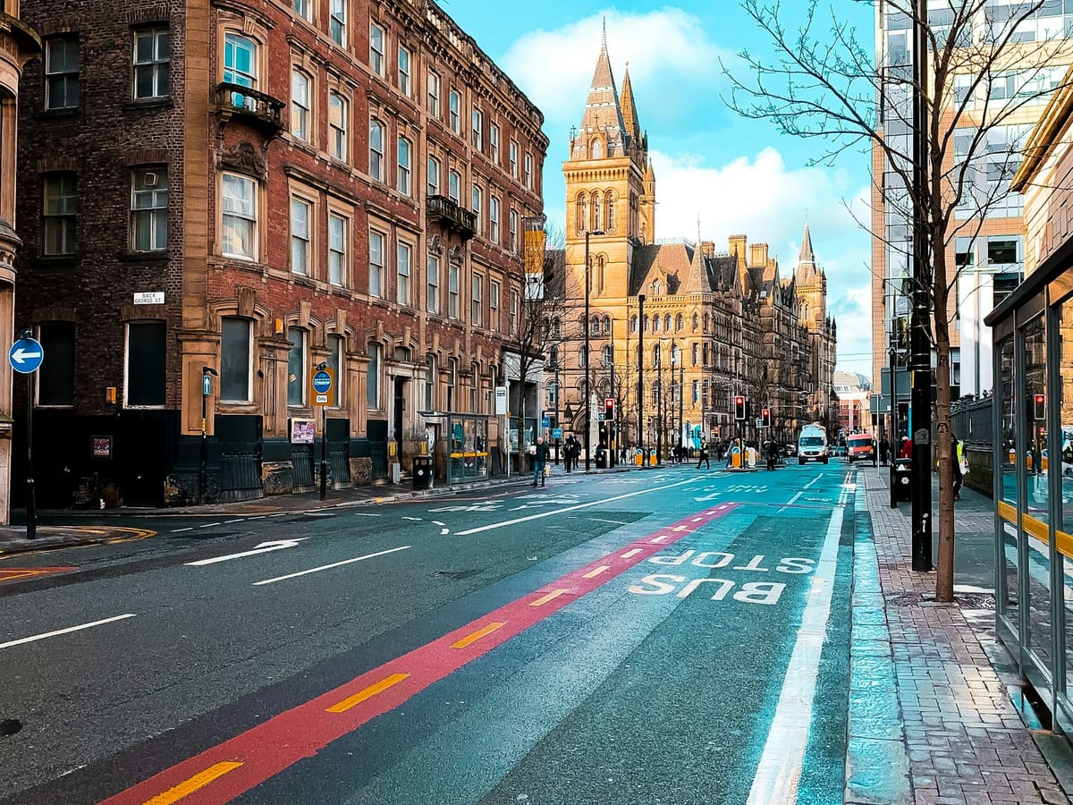 a city street with buildings and a clock tower in the background
